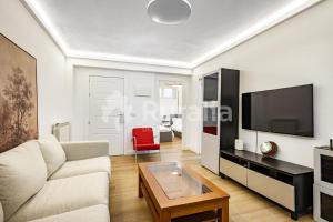 a living room with a couch and a tv at QUINTA PORTIELLO Ribadesella in Ribadesella