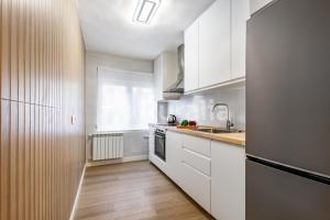 a kitchen with white cabinets and a sink at QUINTA PORTIELLO Ribadesella in Ribadesella