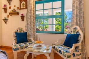 a living room with two chairs and a table at Seclude Hampi 1800 in Sandūr