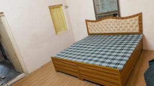 a bedroom with a bed with a checkered mattress at Arihant Guest House in Ujjain +5 photos