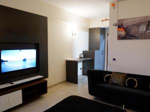a living room with a couch and a flat screen tv at lucknowi stay in Lucknow +19 photos