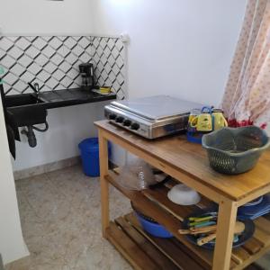 a kitchen with a table with a toaster and a sink at Saloon lodge in Antsiranana
