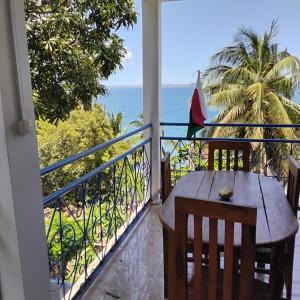 a balcony with a table and a view of the ocean at Saloon lodge in Antsiranana
