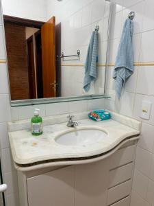 a bathroom with a sink and a mirror at Quarto em ótima localização in Botucatu +21 photos
