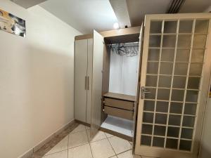 a bathroom with a closet with a glass door at Quarto em ótima localização in Botucatu