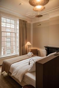 a bedroom with a large bed and a chandelier at ADAM & EVE Paleisstraat in The Hague