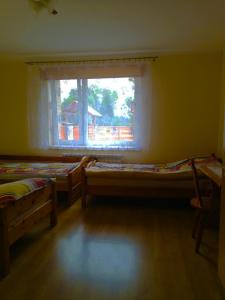 a room with two beds and a window at Agroturystyka Za Zakrętem in Tarnówka