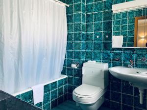 a blue tiled bathroom with a toilet and a sink at Ferienwohnungen Albana in Silvaplana +24 photos