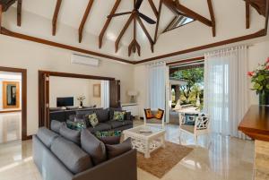 a living room with a couch and a table at Heritage The Villas in Bel Ombre