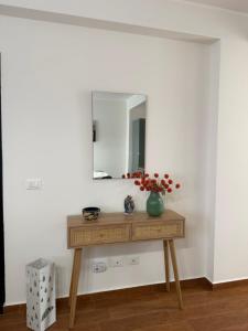 a dressing table with a mirror on a white wall at Vinaka Etna in Biancavilla