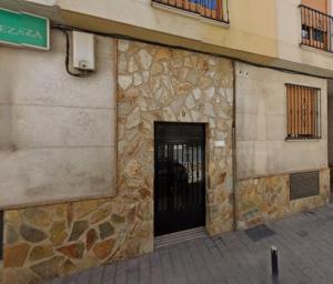 a building with a stone wall with a door at The Llanete Collection 01 in Martos