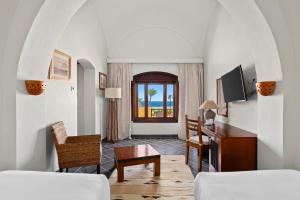 a living room with a bed and a desk and a tv at Swissotel Resort El Quseir in Quseir