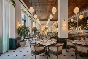 a restaurant with tables and chairs and potted plants at Six Senses London in London