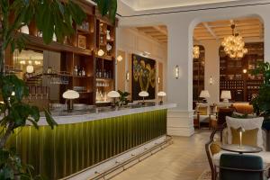 a bar in a restaurant with a green wall at Six Senses London in London