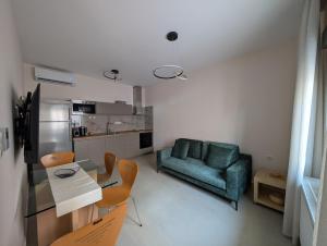 a living room with a green couch and a table and chairs at Ekavis House and Terrace in Kavála
