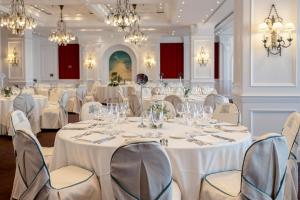 a banquet room with white tables and chairs and chandeliers at Hotel de Londres y de Inglaterra in San Sebastián