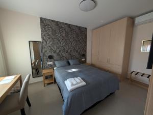 a bedroom with a blue bed and a table and a mirror at Ekavis House and Terrace in Kavála