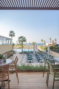 a patio with chairs and tables and a pool at Dan Panorama Tel Aviv Hotel in Tel Aviv