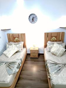 a bedroom with two beds and a clock on the wall at Ray CaboNegro Sea & Pool View in Cabo Negro +24 photos