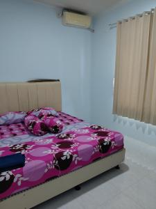 a bedroom with a bed with a purple comforter at Blue Beach Villa Anyer in Pasauran