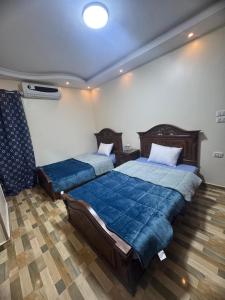 a bedroom with two beds with blue sheets at Giza - faisal in Cairo