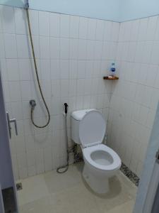 a bathroom with a toilet and a shower at Blue Beach Villa Anyer in Pasauran +3 photos