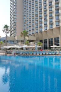 a large swimming pool in front of a hotel at Dan Panorama Tel Aviv Hotel in Tel Aviv