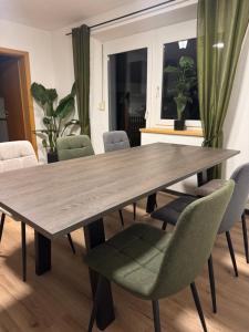 a dining room with a wooden table and chairs at Moderne große Wohnung mit Garten in Hausham +35 photos