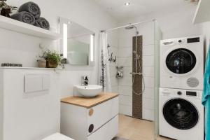 a white bathroom with a sink and a washing machine at Mårslet - close to ocean and city in Mårslet