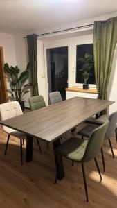 a wooden table with chairs in a living room at Moderne große Wohnung mit Garten in Hausham