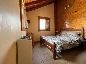 a bedroom with a bed in a wooden room at Cabañas Las Cascadas in Caviahue