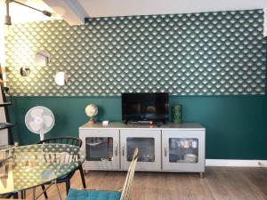 a living room with a tv on top of a cabinet at Rempart Doré in Saint Malo +16 photos