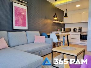 a living room with a couch and a table at 365PAM - Apartament nr 32 w Mielenku - BASEN KRYTY, ANIMACJE DLA DZIECI, JACUZZI, SAUNA,PLAC ZABAW W CENIE in Mielenko
