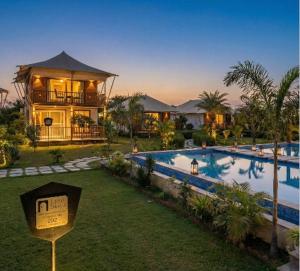 a house with a swimming pool in front of a house at Luxe Stayz Signature Pushkar in Pushkar +165 photos
