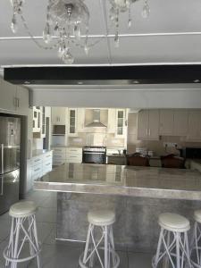 a kitchen with a large island with bar stools at Abebe Guest House in George