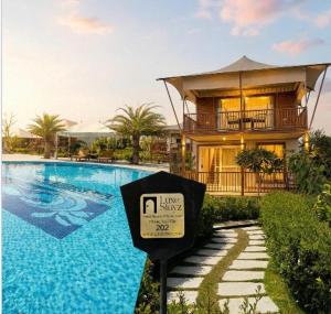 a sign in front of a house with a swimming pool at Luxe Stayz Signature Pushkar in Pushkar