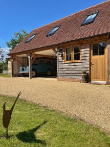 a bird standing in the grass in front of a house at Roost in Heyshott in Midhurst +29 photos