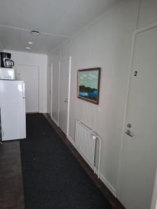 ein Flur mit einem Kühlschrank und einem Gemälde an der Wand in der Unterkunft Ruska Bed & Breakfast in Taivalkoski