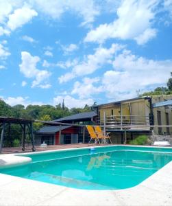 a swimming pool in front of a building at Tere & Tino Cabañas in Río Ceballos