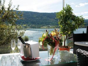 una mesa con una botella de vino y flores. en Seehotel Hoffmann, en Steindorf am Ossiacher See