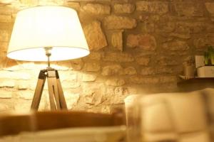 a lamp in a room with a stone wall at Delizioso Appartamento Francesco House Family in Assisi