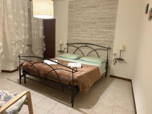 a bedroom with a bed and a brick wall at Delizioso Appartamento Francesco House Family in Assisi +12 photos