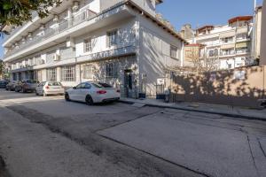 a white car parked in front of a building at Meteora Rockside Lodge in Kalabaka
