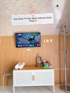 a room with a tv on a wall with a table at Villa Syahdu1 Tawangmangu in Tawangmangu