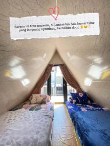 a room with two beds and a sign that reads karma hit three mexican at Villa Syahdu1 Tawangmangu in Tawangmangu