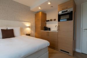 a small bedroom with a bed and a sink at Hotel Zest Den Haag - Scheveningen in Scheveningen
