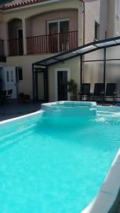a large pool of blue water in front of a building at Palais Cathare in Bélesta