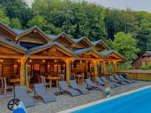 a pavilion with chairs and tables and a pool at Barlogul Ursului in Baia Mare