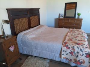 a bedroom with a bed and a dresser and a mirror at Los del Sur cabañas in Comodoro Rivadavia