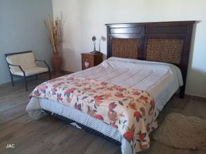 a bedroom with a bed and a chair at Los del Sur cabañas in Comodoro Rivadavia +3 photos
